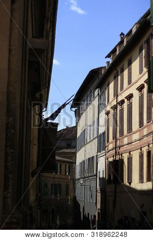 Ancient Tuscan Walled City Houses With Towers And Stone Walls And Paved Cobbled Streets In Italy