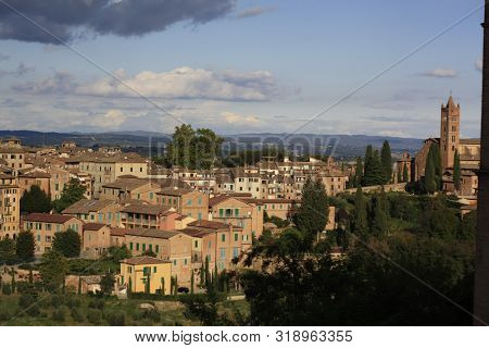Ancient Tuscan Walled City Houses With Towers And Stone Walls And Paved Cobbled Streets In Italy