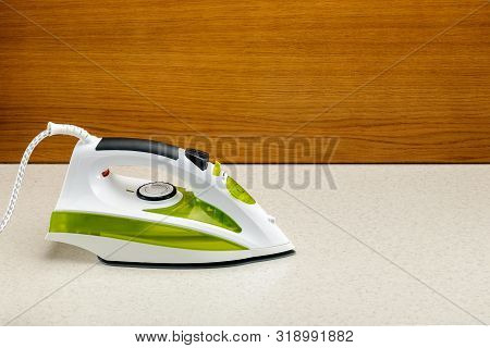 Electrical Green And White Hand Iron On The Wood And Marble Background With Copy Space