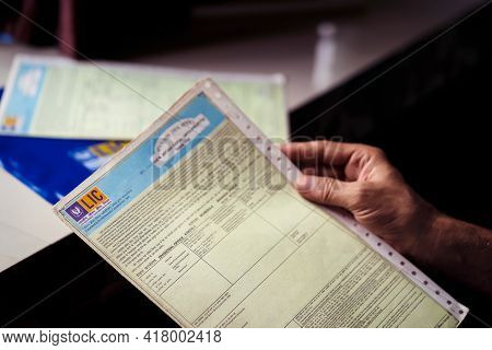 West Bengal, India, January 28, 2021 : A Man Or Lic Policy Holder Looking At His Life Insurance Pape