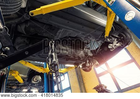 Bottom Pov Big Modern Suv Car With Removed Gearbox Raised On Lift Elevator At Workshop Service Maint