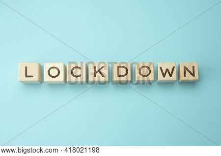 Wooden Blocks With The Inscription Lockdown On A Blue Background. Self-isolation Concept To Prevent 