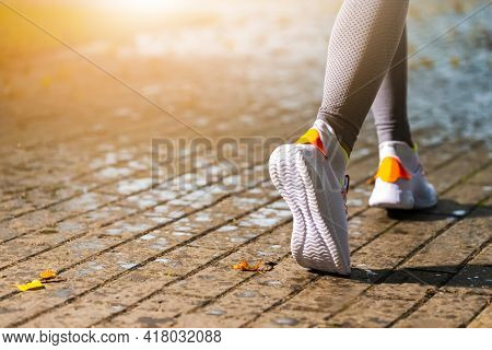 Running Concept. Closeup Of Active Female Runner Feet During Running Exercise Outdoor.