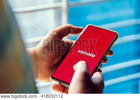 Kolkata, India, April 21, 2021 : Man Hand Holding A Mobile Phone And Opening Zomato App For Food Del