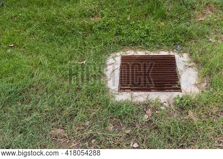 Close Up Grille Drain Of Sewer Around The Grass Field . Water Recirculation System. Wastewater Treat
