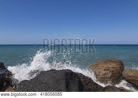Coast And Beach Of Vlychada On Santorini Island In Greece. In The Background Blue Sky And Waves At S