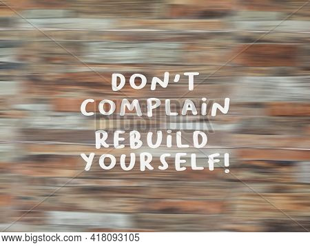 Motivational Quote - Don't Complain, Rebuild Yourself. Sign On Blurry Wooden Pattern Texture Backgro