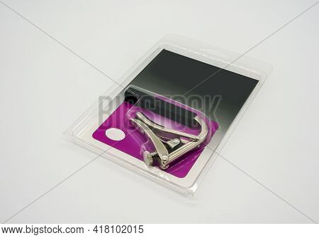 Silver Nickle Capo For Acoustic And Classical Guitar In Plastic Packaging Isolated On White