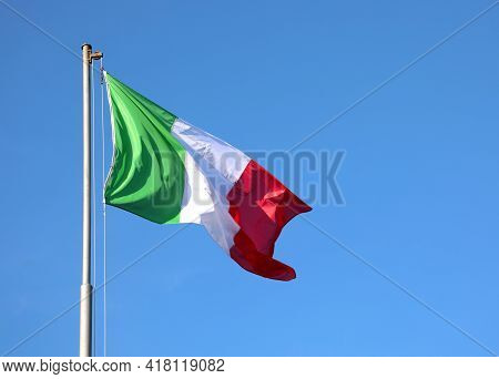 Italian Flag Waving With Vivid Colors And The Blue Sky In The Background