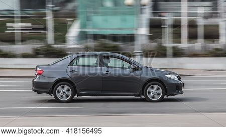 Side View Toyota Corolla E140 Moving On City Road. Driver In Gray Sedan Rushes For Job. Moscow , Rus