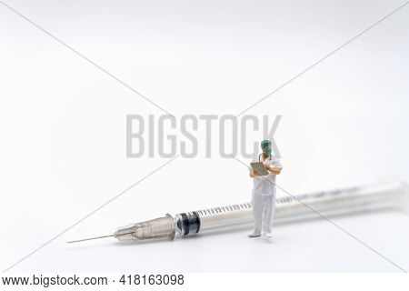 Healthcare And Vaccine Consept. Doctor Miniature Figure People With Surgical Face Mask And ยatient F