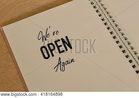 Phrase We're Open Again Written On Notebook