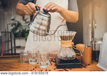 Person Holding Kettle Pour Hot Water Over The Coffee Powder. Making Filter Coffee. Drip Coffee.