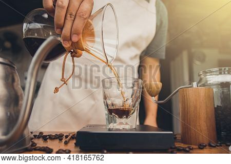 Barista Holding Coffee Drip Jug Pour Coffee To Glass Cup. Making Filter Coffee. Drip Coffee.