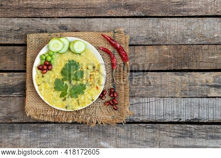 Khichdi Or Cracked Wheat Khichuri In A Plate With Coriander Leaf, Green Pea, Cucumber Slices And Pea