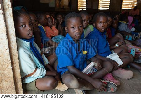 Mzuzu, Malawi. 30-05-2018. Portrait Of A Group Of Black Children Attending School Sitting On The Flo