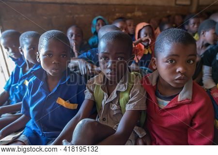 Mzuzu, Malawi. 30-05-2018. Portrait Of A Group Of Black Children Attending School Sitting On The Flo