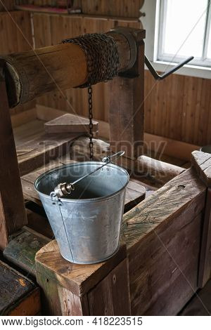 Metal Bucket At The Edge Of The Well. Vazheozersky Spaso-preobrazhensky Monastery. The Overhead Chap