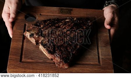 A Juicy Medium-rare Beef Steak Of Meat Lying On A Wooden Board In The Hands. The Perfect Image For Y