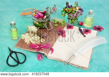 Natural herbal medicine for alternative remedies with flowers and herbs steeping in a jar with oil to make aromatherapy essential oil with hemp notebook and quill pen. Naturopathic health care.