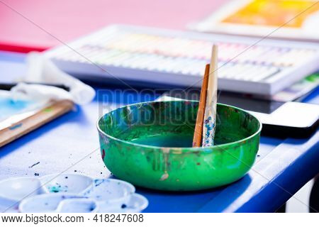 Prepare Some Water Painting Supplies On Desk. Contains A Plastic Bowl For Adding Water To Wash The P
