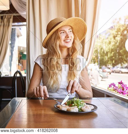 Young Woman At Restaurant Eating Shrimp Salad. Health Food Concept. Fork And Knife. Ountdoor Cafe. H