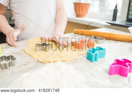 Child's Hands Squeezing Cookie Figures On The Dough. Cooking At Home