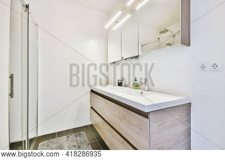 Sink Base Cabinet And Mirror Cabinet In White Tiled Bathroom With Wall Hung Toilet