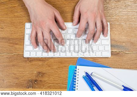 Office Worker Checks Email While Sitting At A Wooden Table.
