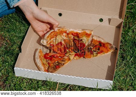 Close-up Of Hands Taking A Slice Of Pizza From A Box