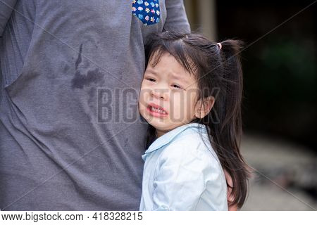 Adorable Asian Girl Is Crying With Tears On Her Cheeks. Child Rested On Her Mother's Belly. Children