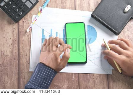 Top View Of Man Hand Using Smart Phone On Office Desk