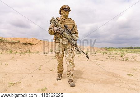 Fully Equipped And Armed Soldier With Rifle In The Desert. Concept Of Military Anti-terrorism Operat