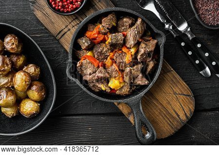 Mongolian Beef, Pieces Of Beef Stewed In Soy Sauce Set, In Cast Iron Frying Pan, On Black Wooden Bac