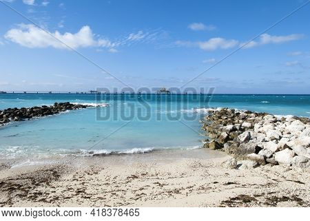 The View Of Grand Bahama Island Small Beach Covered With Algae And A Wet Dock Installation In A Back