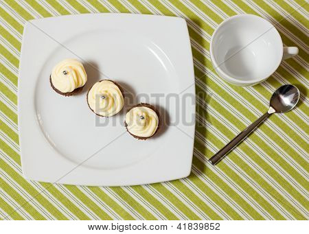 Chokolade Cupcakes med sølv drysser på toppen på hvid plade