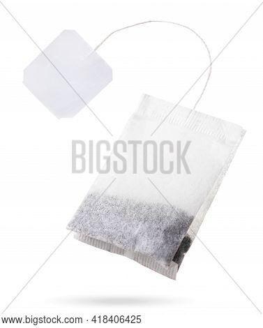 Teabag With White Label Flies Close Up On White Background, Isolated. Tea Bag Mockup
