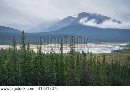Sunwapta River Bed On A Very Cloudy, Rainy Day In Canadian Rockies. Cold Harsh Weather In Jasper Nat