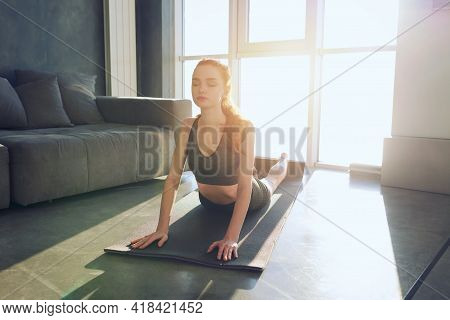 Young Girl Does Gym Exercises During Sunrise. She Is At Home Due To Coronavirus Codiv-19 Quarantine