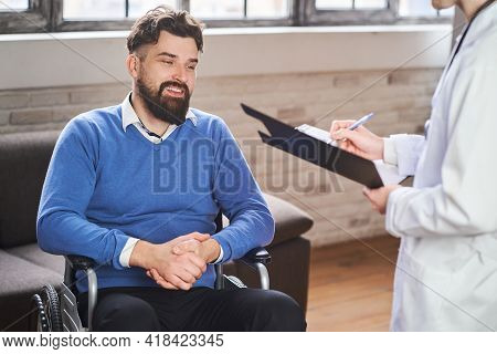 Handsome Ex-serviceman In A Wheelchair Having A Physicians Visit