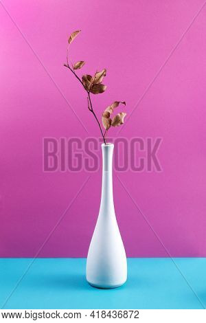 Still Life With A White Vase And A Branch With Dry Leaves