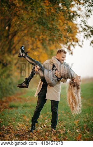A Man Holds His Girlfriend In His Arms, A Happy Couple