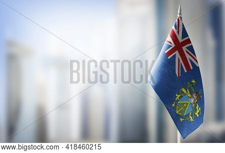A Small Flag Of Pitcairn Islands On The Background Of A Blurred Background