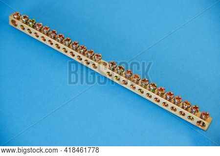 Electrical Copper Busbar For Screw On A Blue Background. Electrical Engineering Concept.