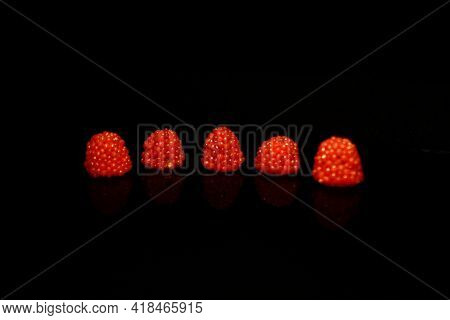 Five Blueberry Red Lke Drops In Lne  Isolated On Black