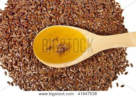 เมล็ด flax เมล็ดและช้อนน้ำมัน closeup แยกต่างหากบนพื้นหลังสีขาว