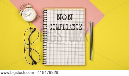 Non Compliance On Notepad With Pen, Glasses And Alarm Clock