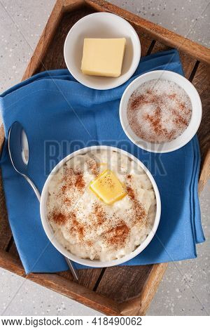 rice pudding with butter cinnamon. french riz au lait, norwegian risgrot, traditional breakfast dessert