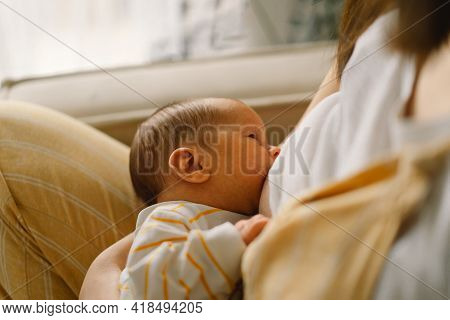 Newborn Baby Boy Sucking Milk From Mothers Breast. Portrait Of Mom And Breastfeeding Baby.