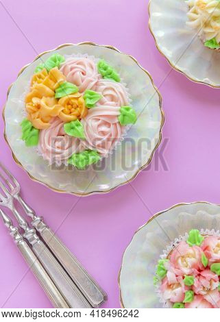 Vertical Over Head Image Of Pretty Cup Cakes Delicately Iced With  Russian Icing Tips Pink Backgroun